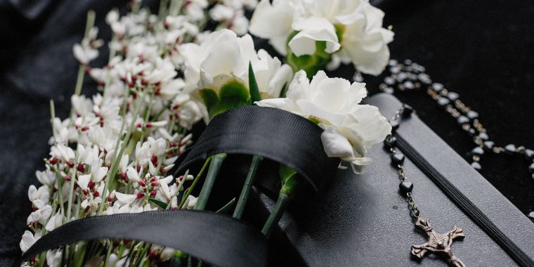 Flores blancas y un rosario en señal de recuerdo