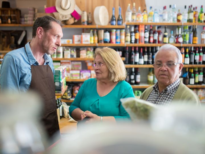 Pareja mayor conversando con un asesor en una tienda