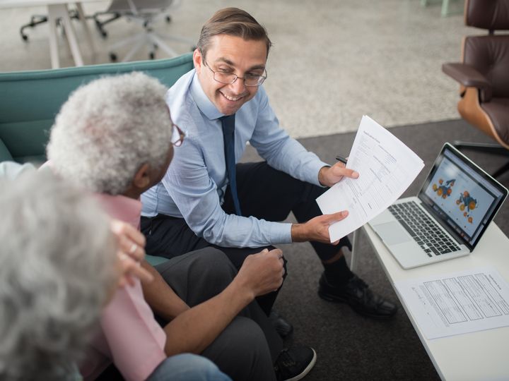 Agente explicando documentos a clientes mayores