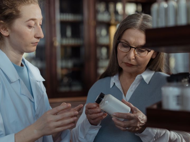Asesora explicando un producto a una clienta en la farmacia