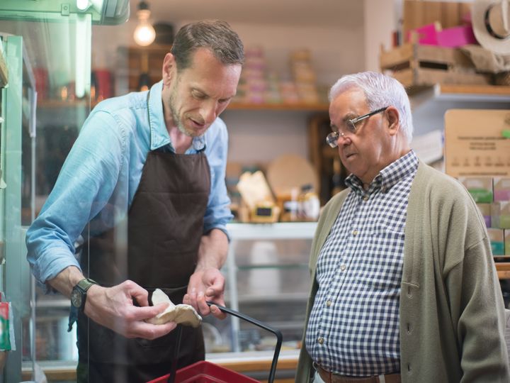 Asesor atendiendo a un señor mayor en una tienda